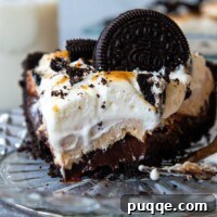 Slice of peanut butter Oreo pie on a glass pie plate topped with an Oreo.