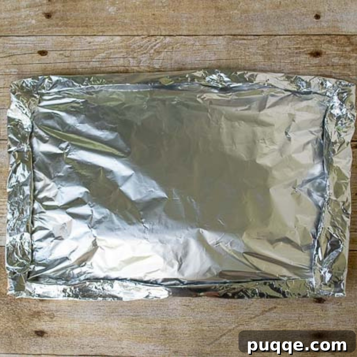 Another image illustrating the final shaping of a securely sealed foil packet, ready for the grill.