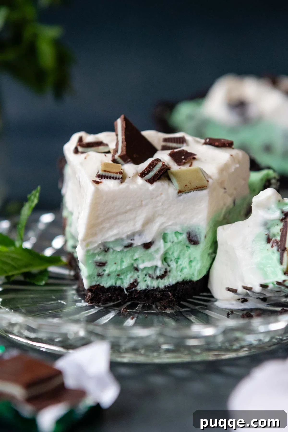 No Bake Chocolate Mint Dream Pie 2 A delectable slice of creamy Andes mint pie on a glass plate, showcasing its layers of chocolate crust, vibrant mint filling, and fluffy whipped topping.