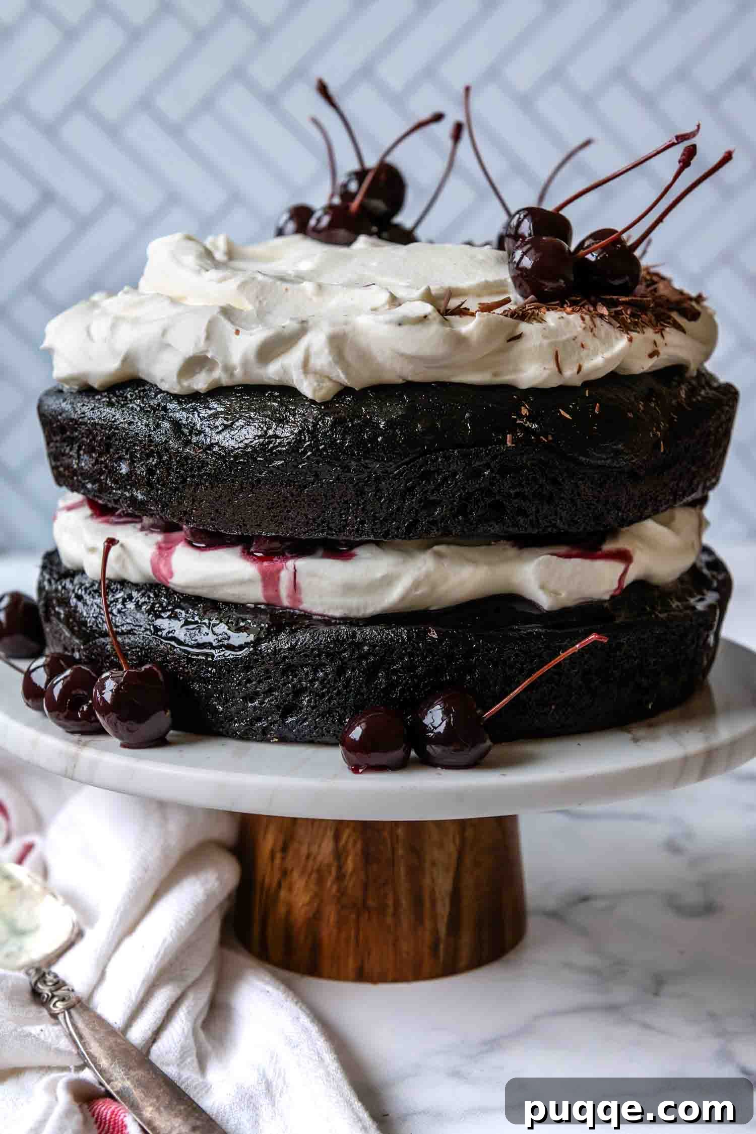 The fully assembled and decorated Gluten-Free Black Forest Cake resting elegantly on a cake stand, ready to be served.