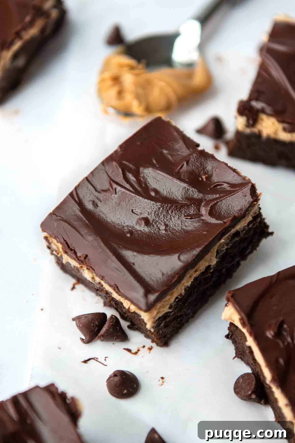 Effortless Gluten Free Zucchini Brownies 7 Top view of a zucchini brownie slice featuring a shiny chocolate glaze over peanut butter frosting, showcasing the perfect layers.