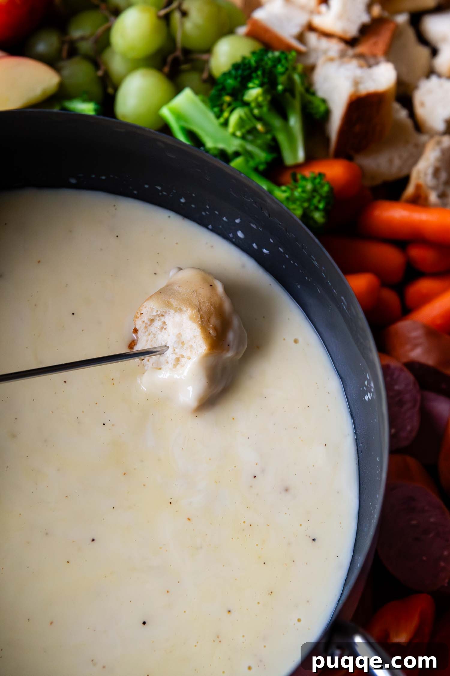 Effortless Creamy Gluten-Free Cheese Fondue 7 A delicious piece of gluten-free bread, perfectly toasted, is being carefully dipped into a bubbling pot of warm, creamy Swiss cheese fondue, ready to be enjoyed.