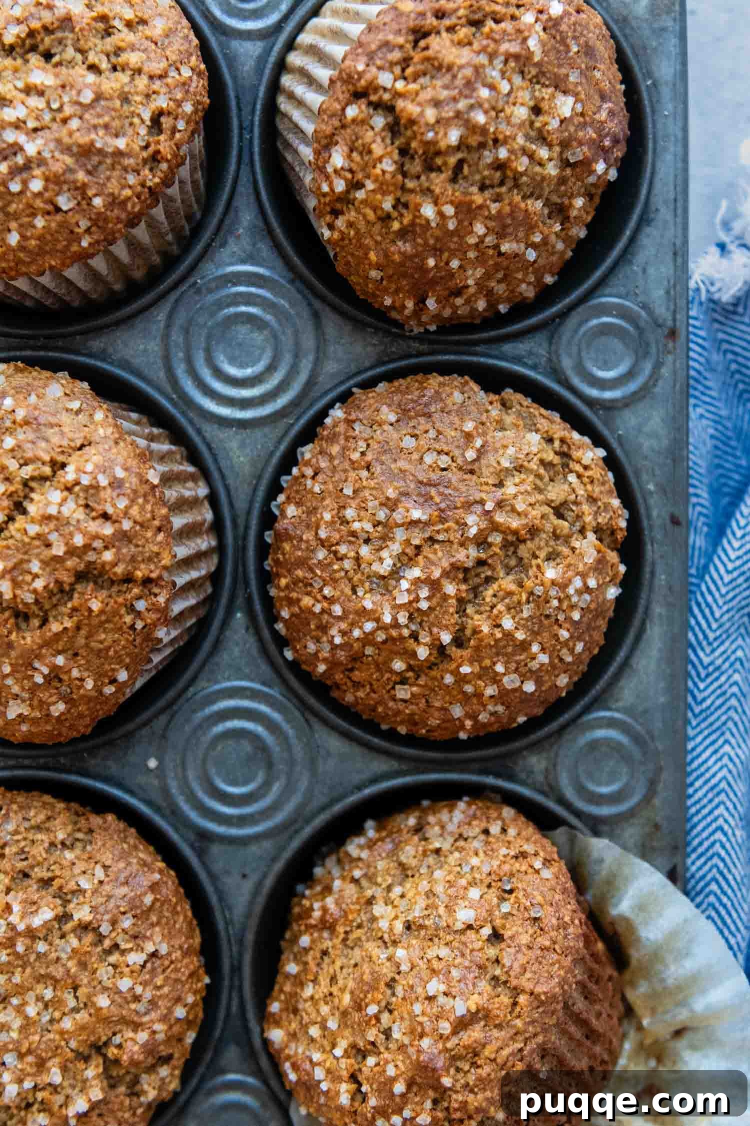 Freshly baked gluten-free oat bran muffins cooling in a muffin tin.