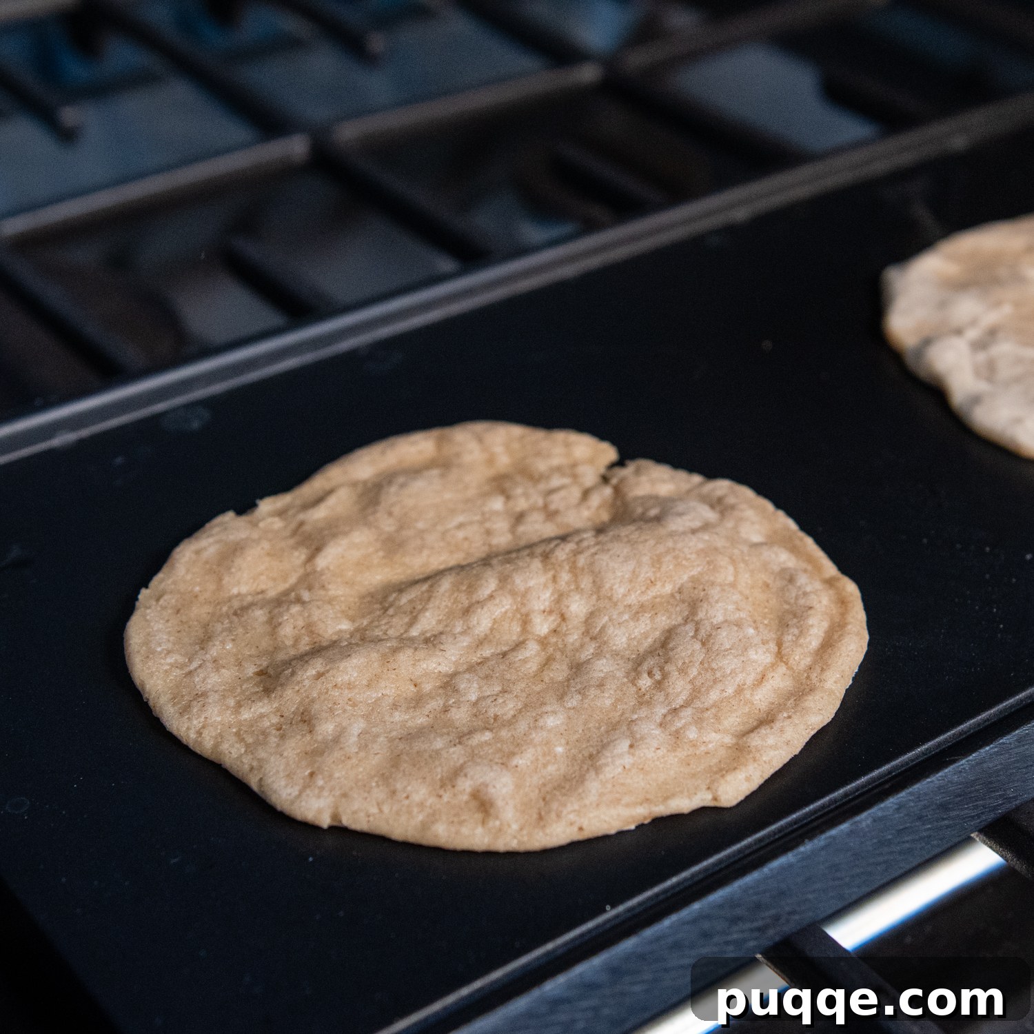 Effortlessly Soft and Pliable Oat Tortillas 8 A finished oat tortilla cooking on a griddle, showing slight puffing indicating perfect doneness.