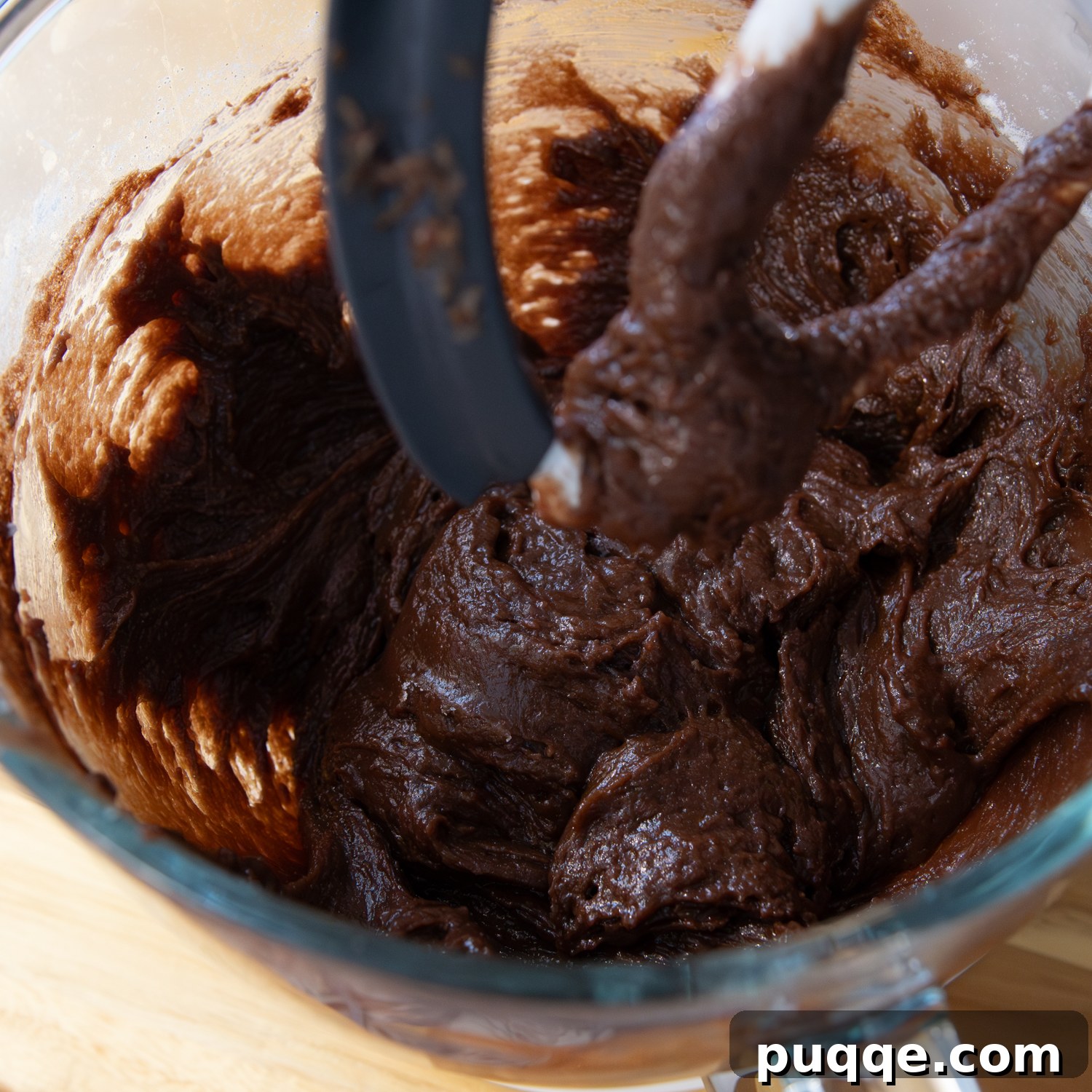 Dry ingredients and hot liquids beginning to mix in a blender, showing a thick initial batter consistency.