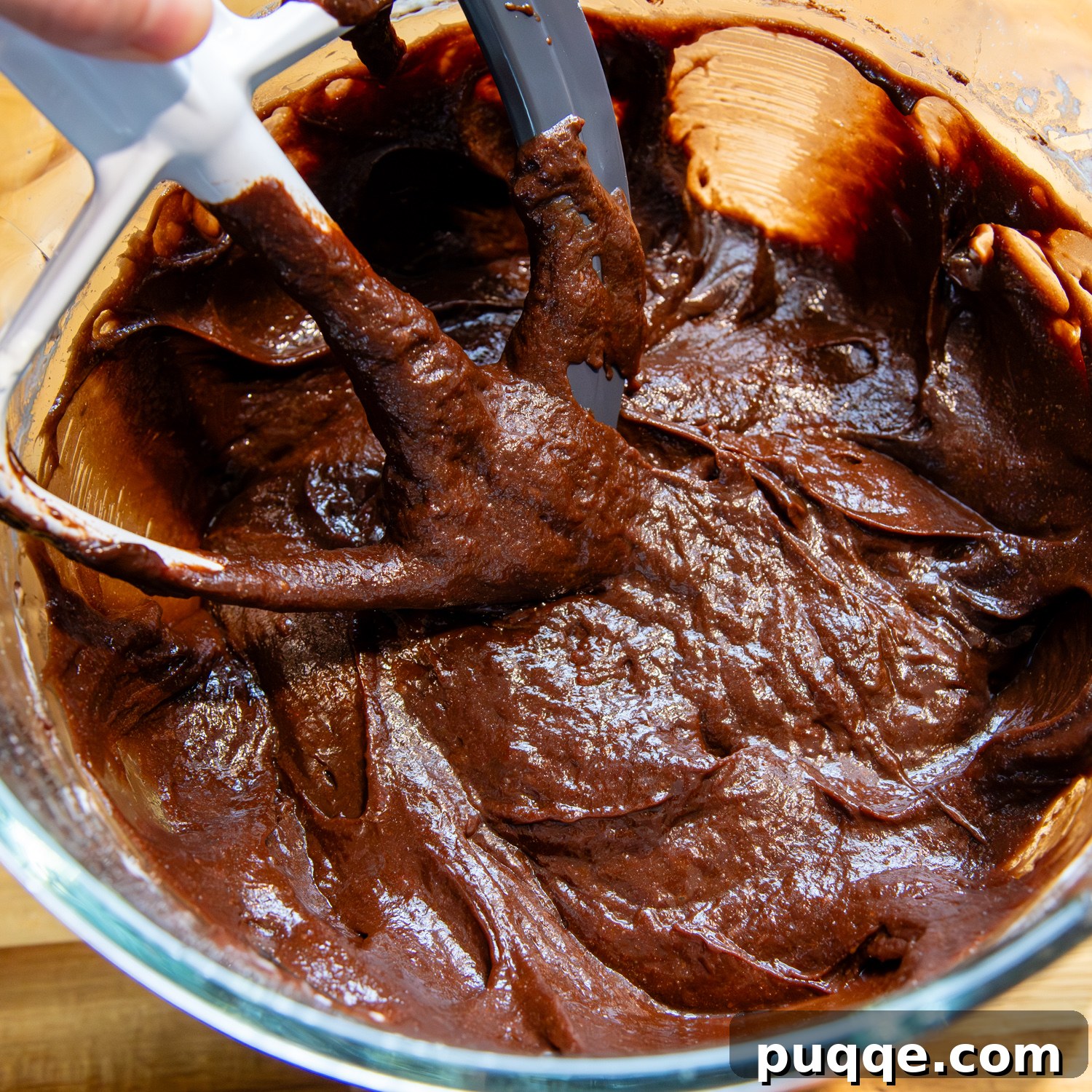 Thick cake batter, after all ingredients are combined, showing a spreadable consistency in a blender.