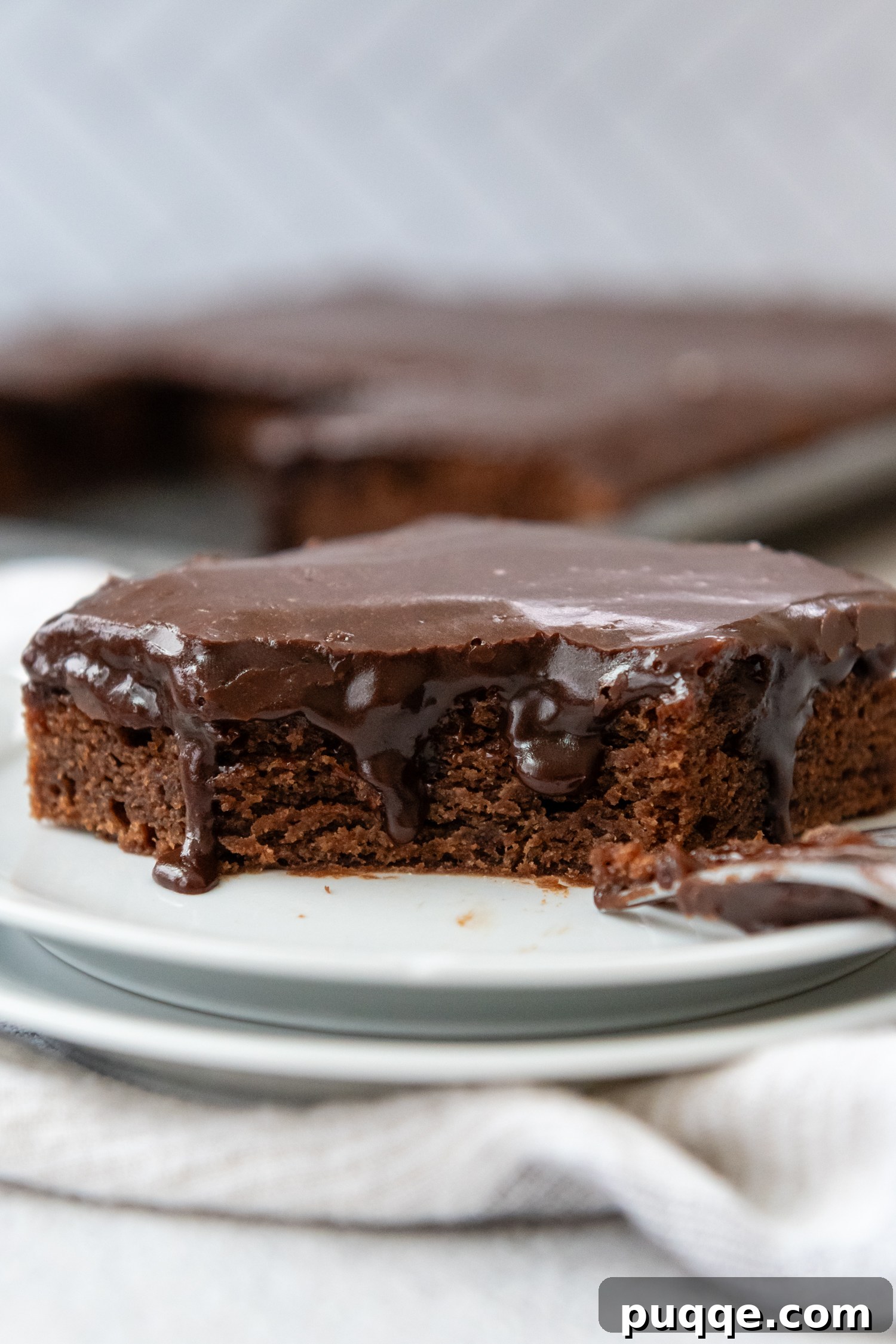 A perfectly sliced piece of Gluten-Free Texas Sheet Cake on a white plate, showcasing its rich chocolate color, tender texture, and glossy glaze.