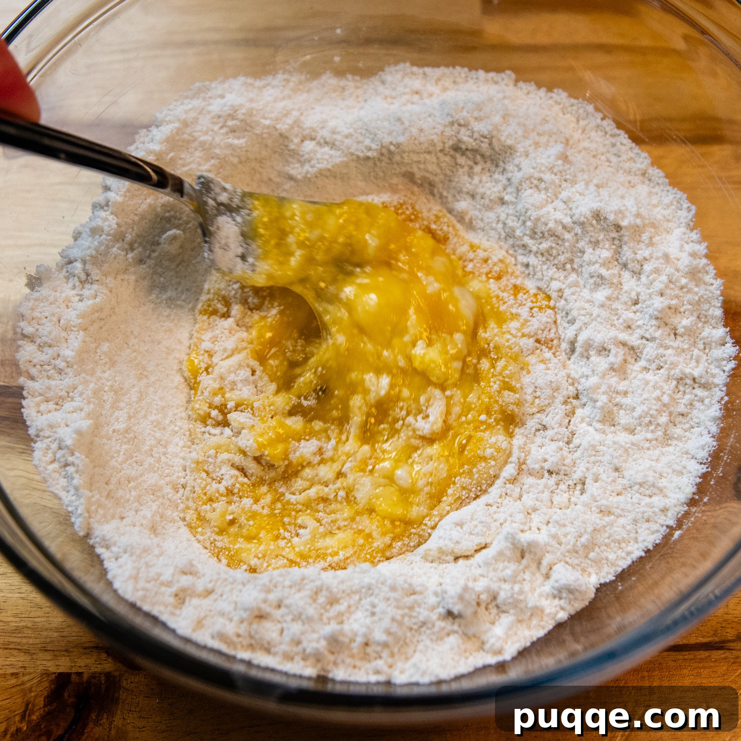 Egg being added to flour.
