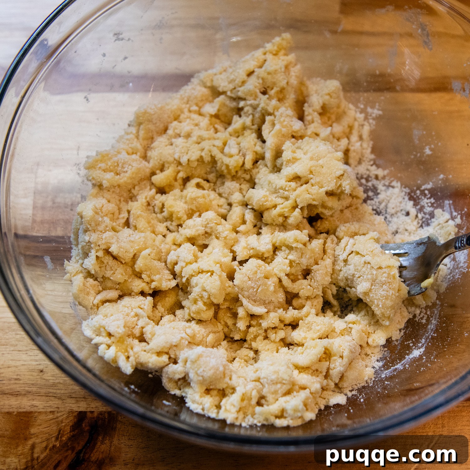 Pasta ingredients being mixed by hand.
