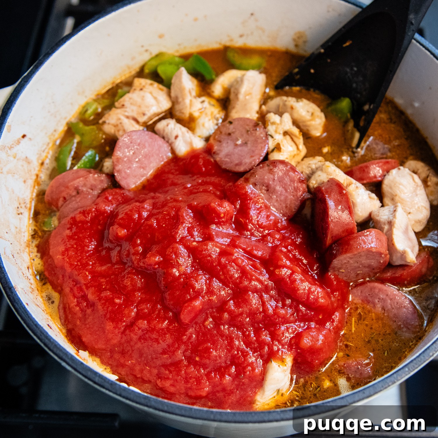 Tam Tadında Glutensiz Tek Tencere Jambalaya 8 Crushed tomatoes, chicken broth, and tomato paste added to jambalaya ingredients.