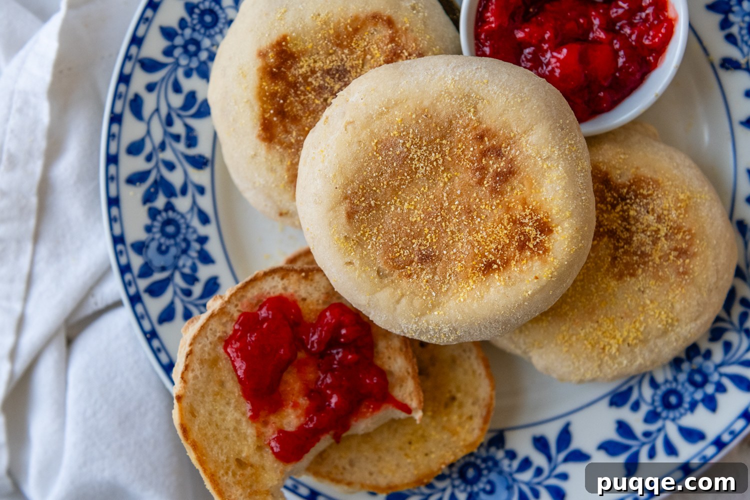 Multiple muffins on a plate with the top muffin showing the golden brown outside.