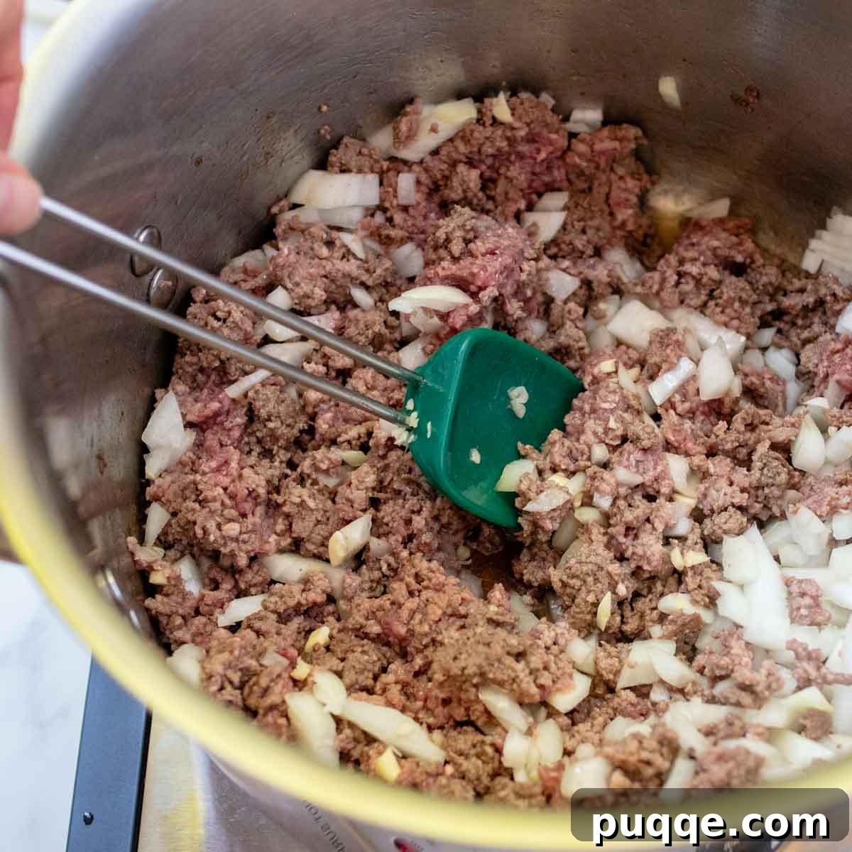 The Perfect Stuffed Pepper Soup 4 A large pot with ground beef, onions, and garlic cooking on the stove.