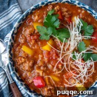 overhead shot of stuffed pepper soup in a blue bowl with blue napkin next to it