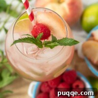 looking down on top of a raspberry peach mojito with fresh mint sprig and straw in the glass