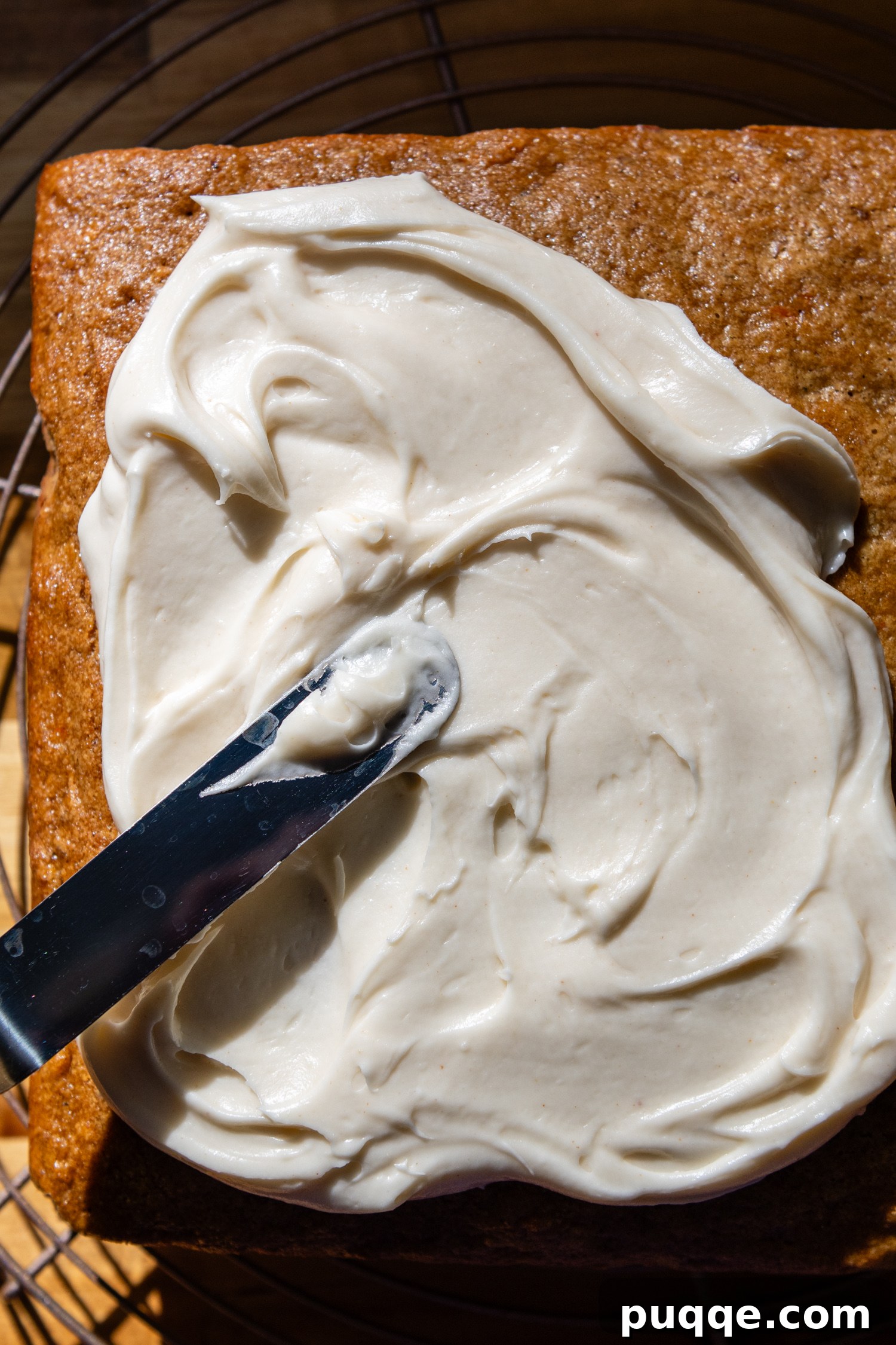 Heavenly Oat Flour Carrot Cake Unbelievably Moist and Light 7 Knife spreading frosting on top of the cake.