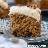 Slice of Oat Flour Carrot Cake sitting on a glass plate.
