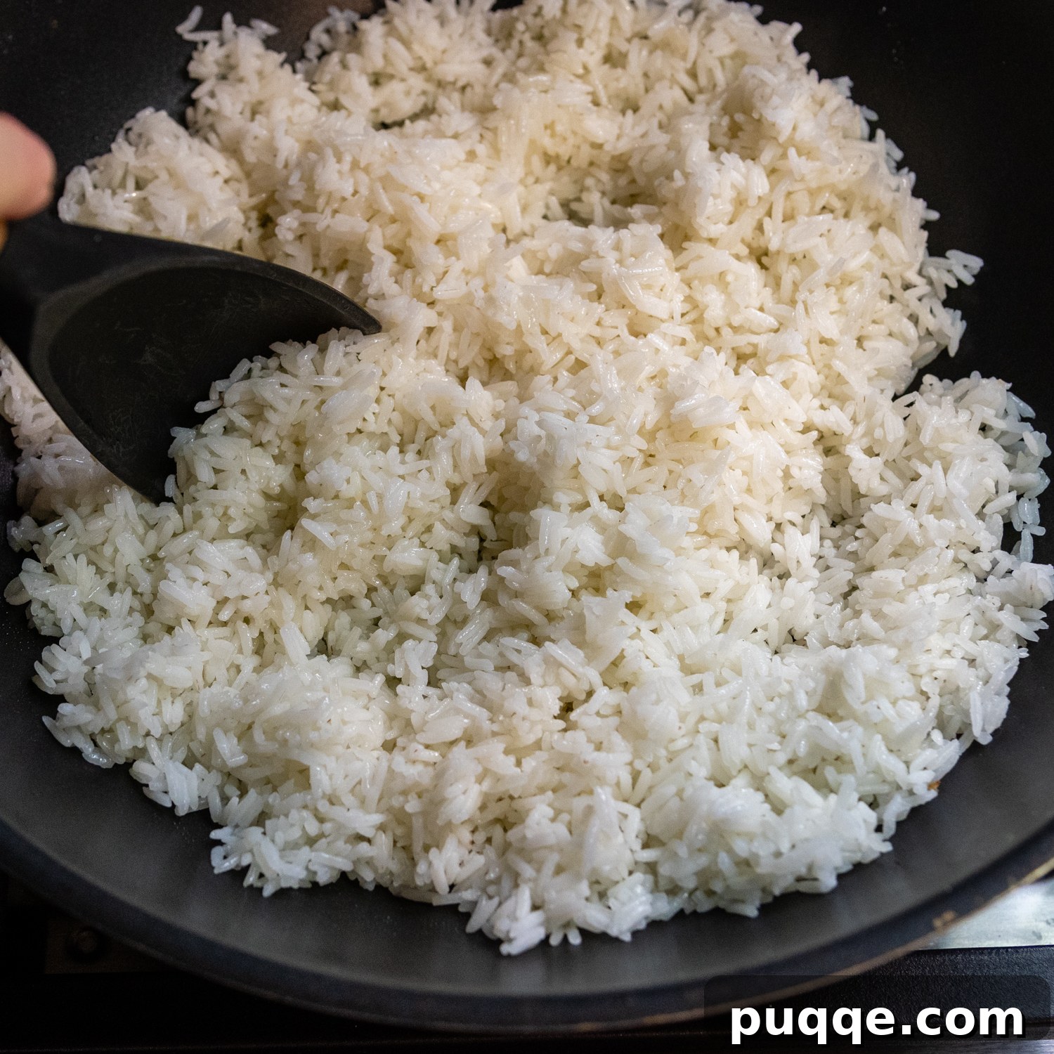 Quick Gluten-Free Fried Rice: Your Perfect Weeknight Meal 4 Close-up of cold, cooked jasmine rice, perfectly separated, in a black bowl with a spoon, ready for frying.
