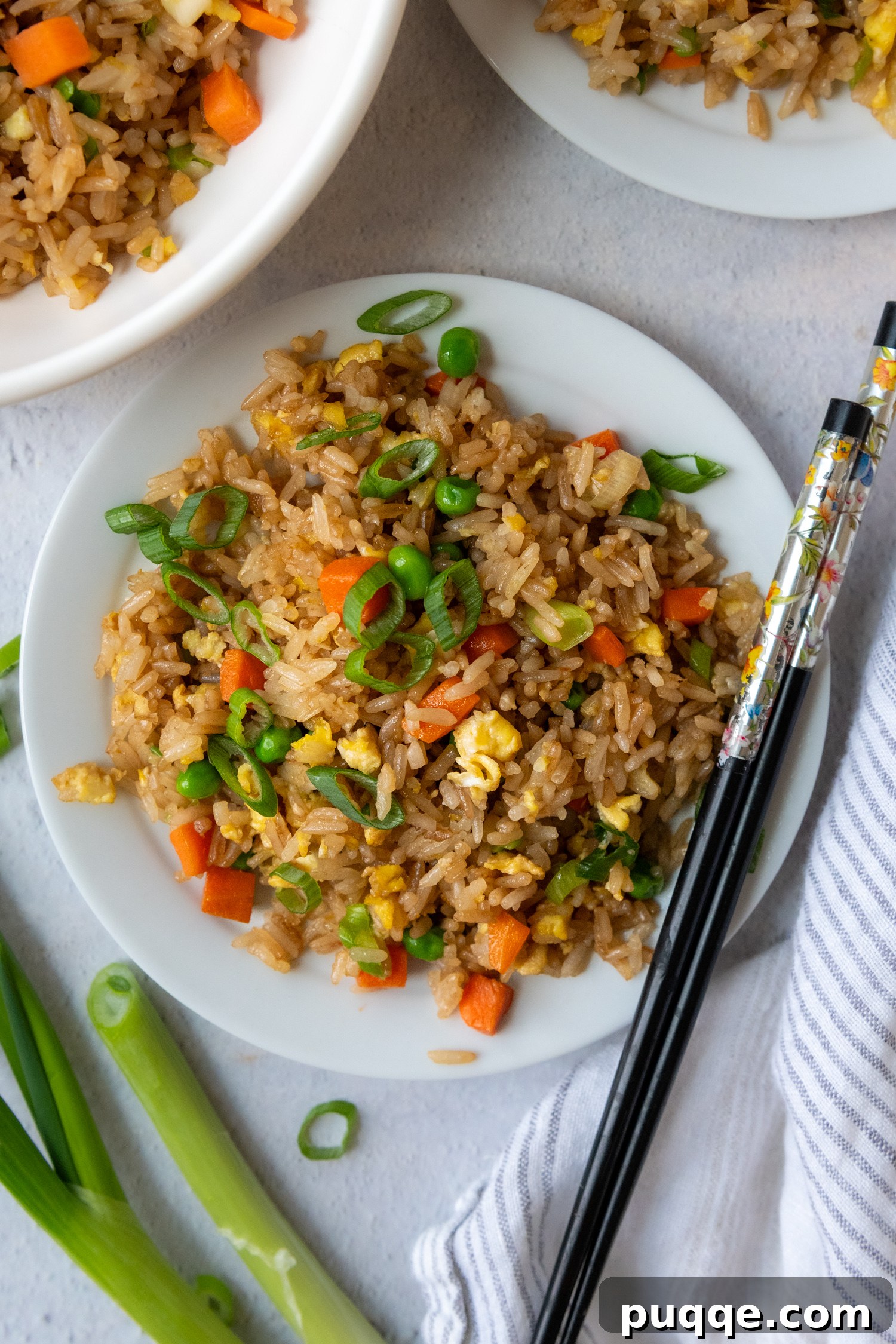 Quick Gluten-Free Fried Rice: Your Perfect Weeknight Meal 8 Gluten-Free Fried Rice plated on a white ceramic dish, with a set of wooden chopsticks resting beside it.