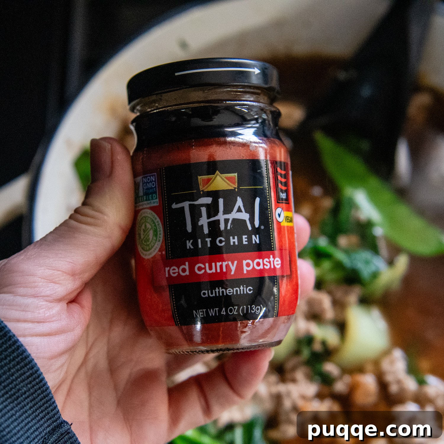 Quick & Creamy Gluten-Free Coconut Ramen Bliss 6 Hand holding a jar of red curry sauce.