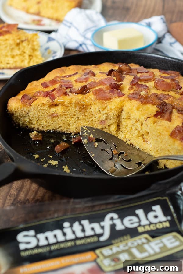 an iron skillet with slices of bacon cornbread cut out of it