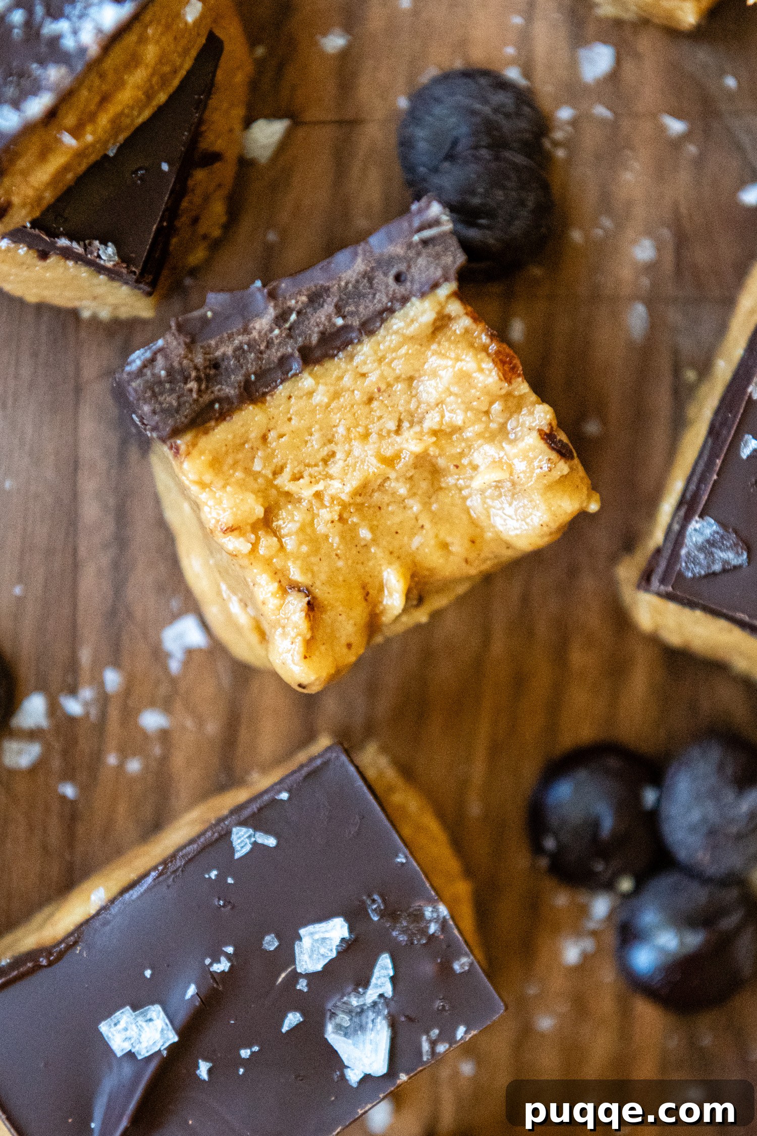 Close up side view of a perfectly layered gluten-free peanut butter bar, showing the smooth textures.