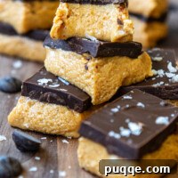 Gluten Free Peanut Butter Bars cut and stacked on a cutting board, showcasing the delicious layers.