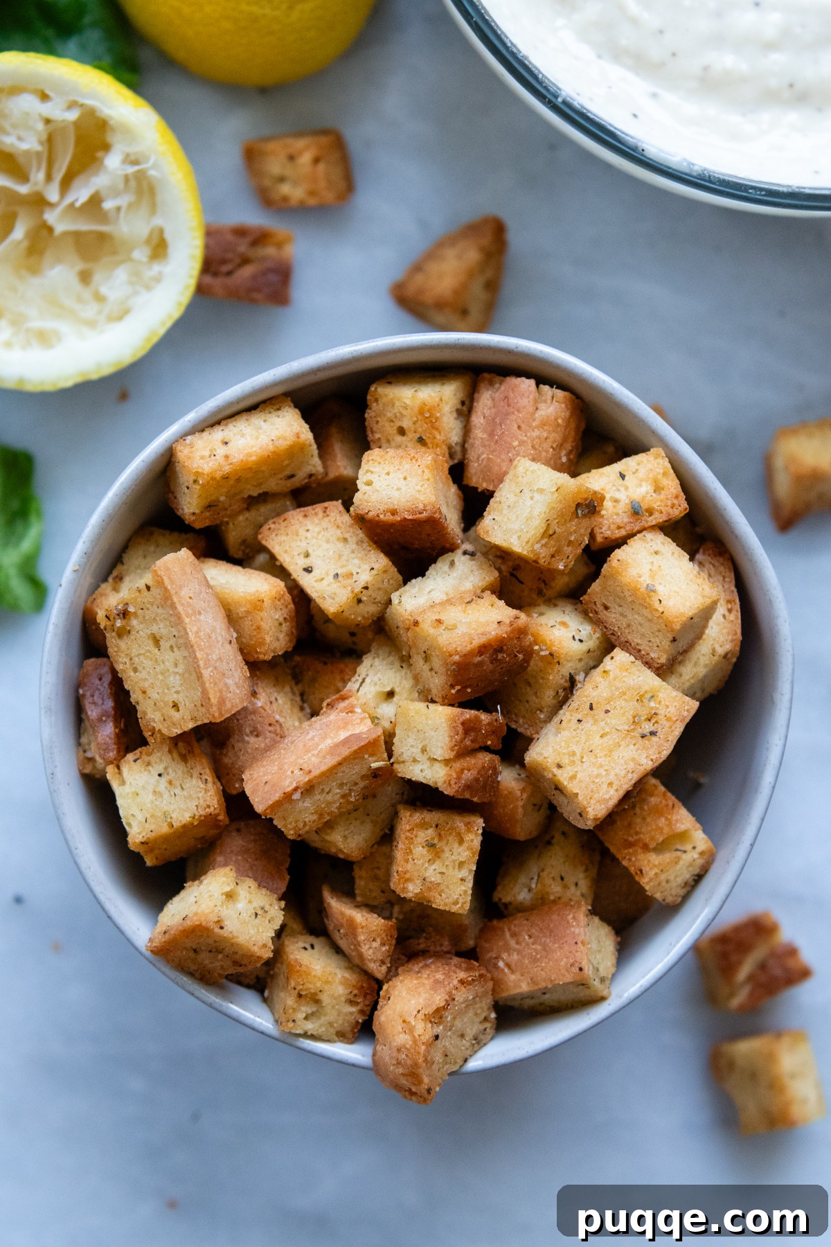 Overhead shot of freshly made, golden-brown gluten-free croutons in a rustic bowl, ready for serving.