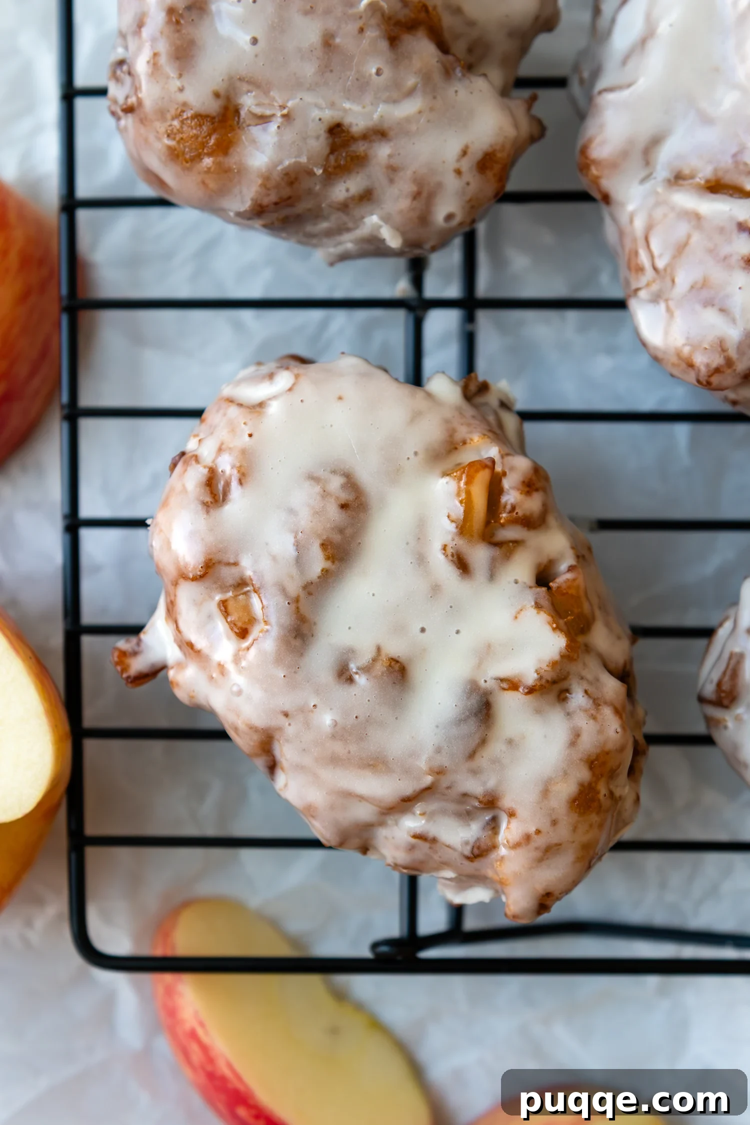No-Fuss Gluten-Free Apple Fritters 2 Gluten-free apple fritter covered in glaze sitting on a drying rack.