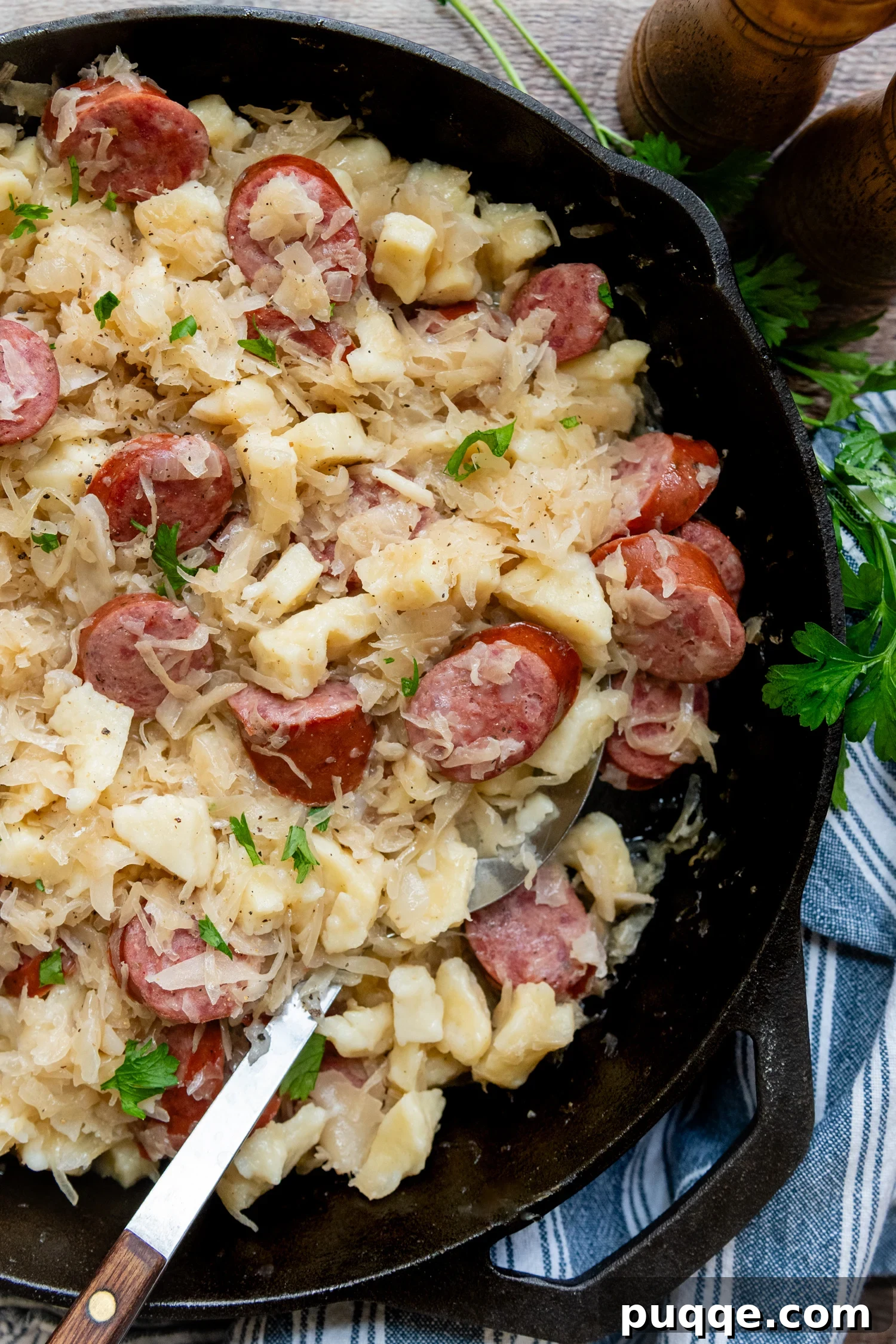 Hearty Gluten-Free German Dumplings and Sausage 2 Gluten-free dumplings and sausage with sauerkraut served in a rustic cast iron skillet, ready to be enjoyed.