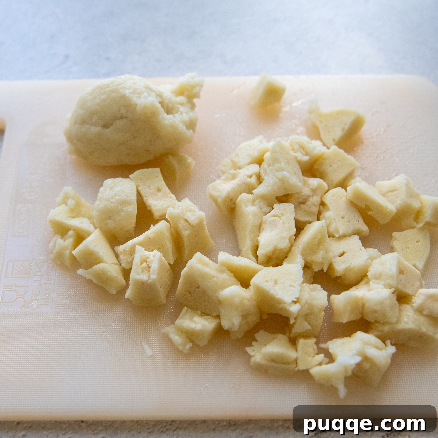 Hearty Gluten-Free German Dumplings and Sausage 7 Cooked gluten-free dumplings neatly arranged on a cutting board, ready for chopping.