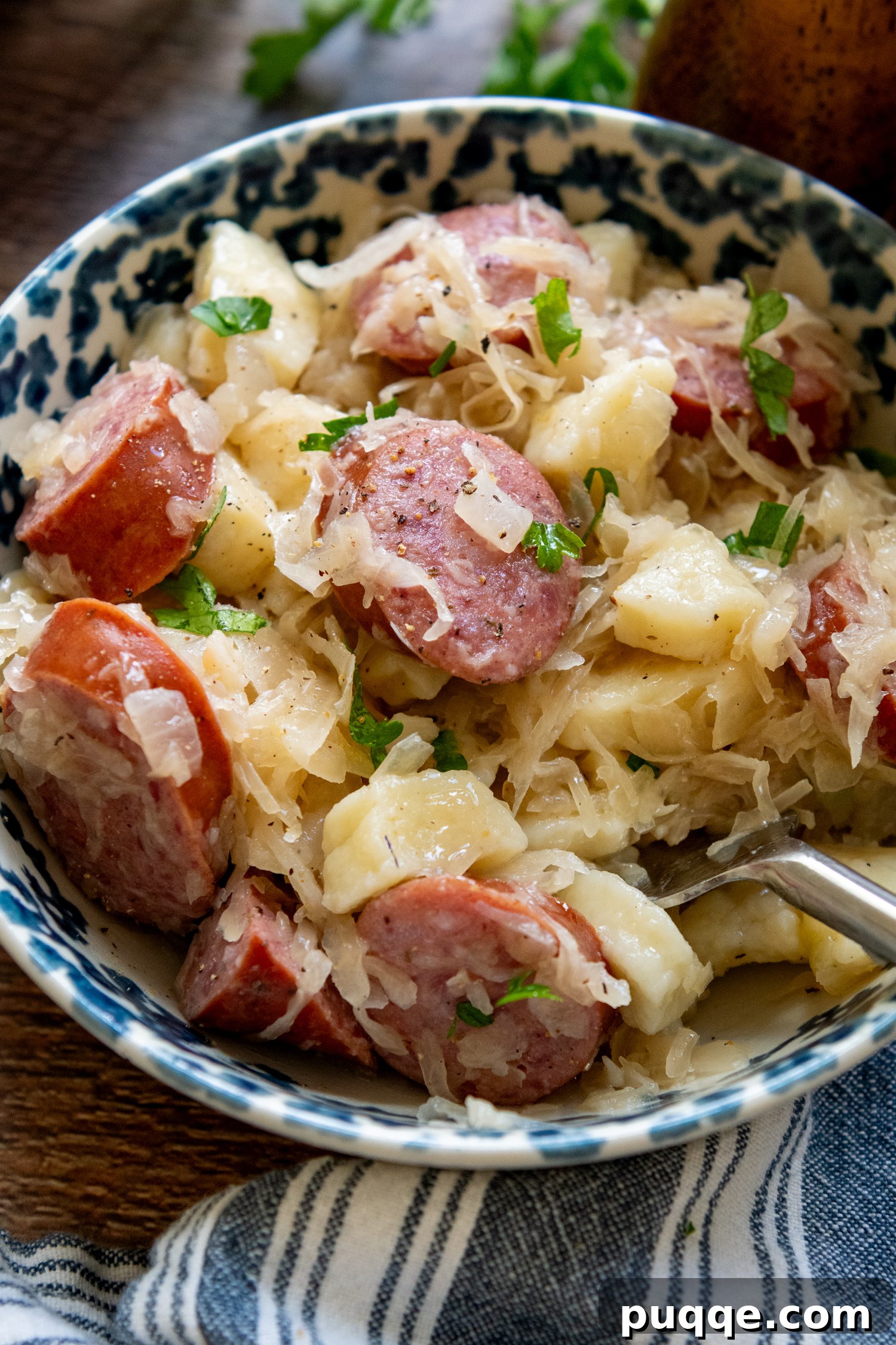 Hearty Gluten-Free German Dumplings and Sausage 10 A single serving of gluten-free dumplings and sausage with sauerkraut in a white bowl, ready to eat.