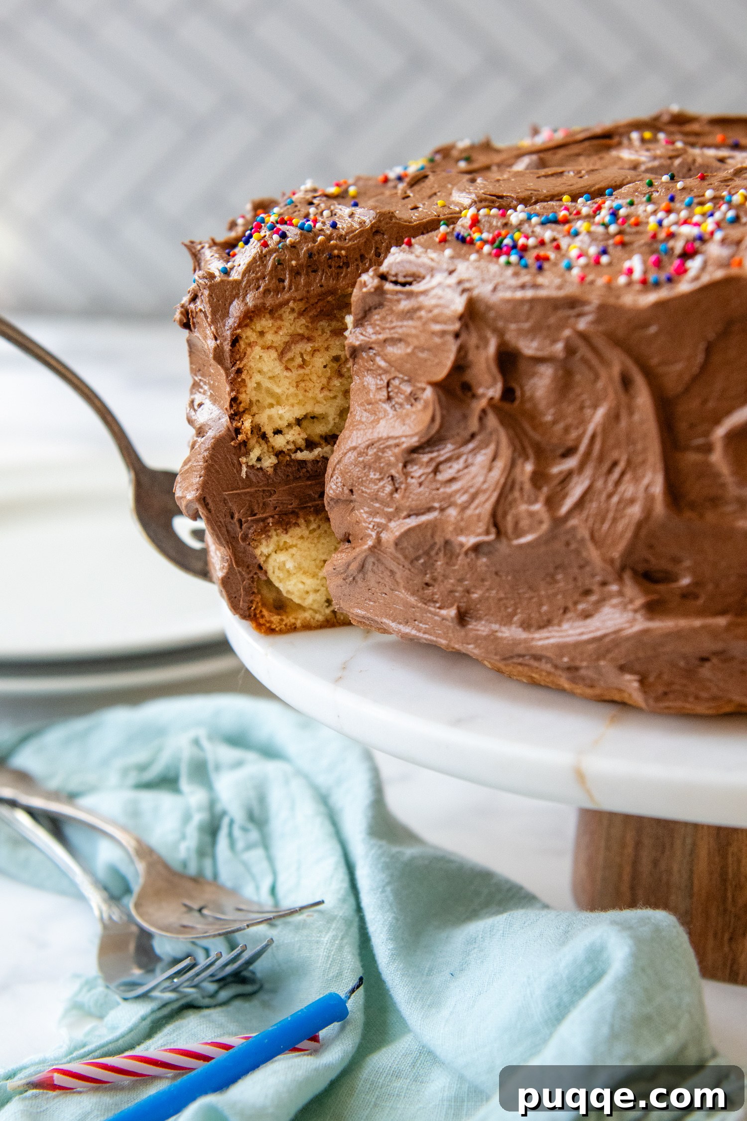 Frosted cake slice being pulled out from the whole cake.