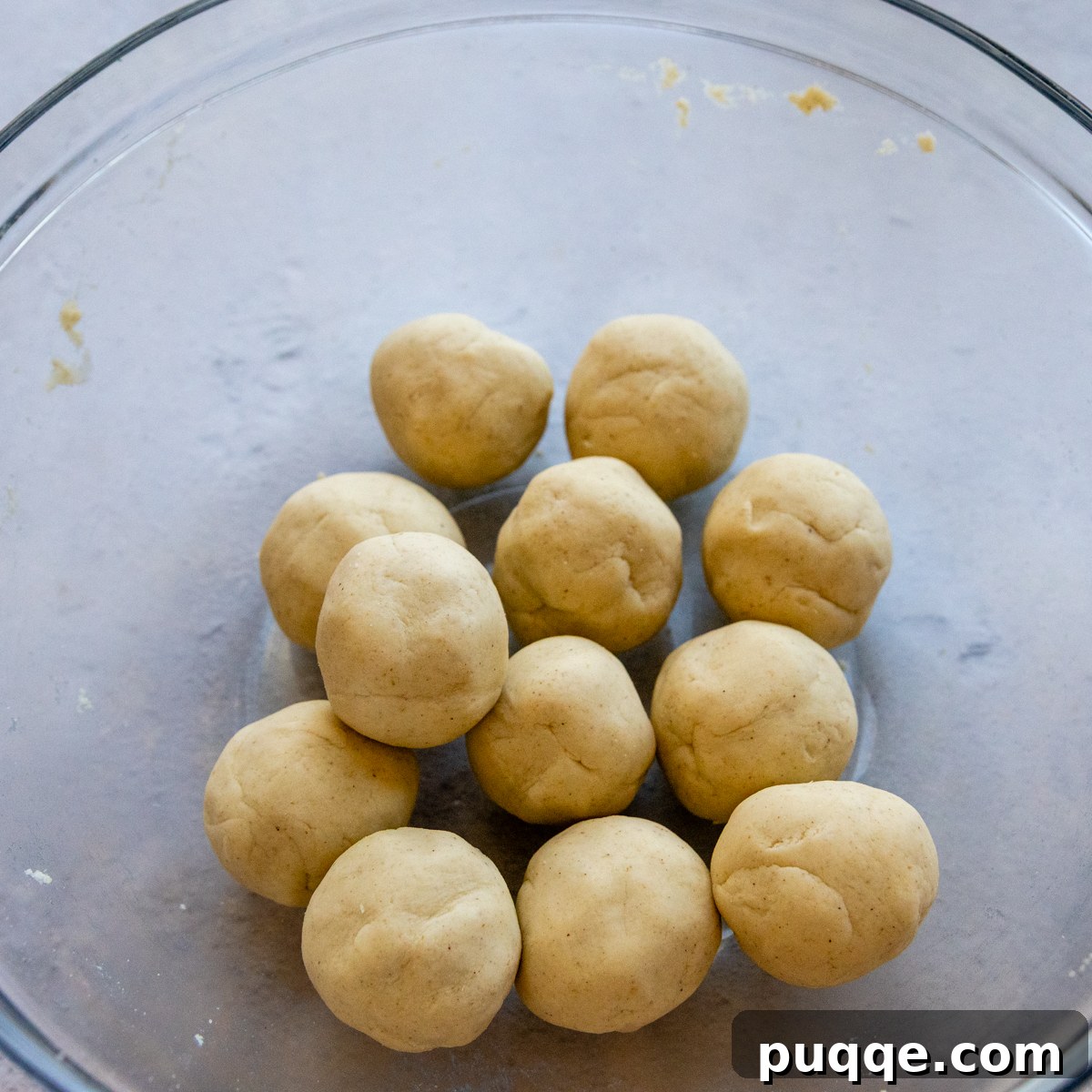 rolled up dough balls in a glass bowl.