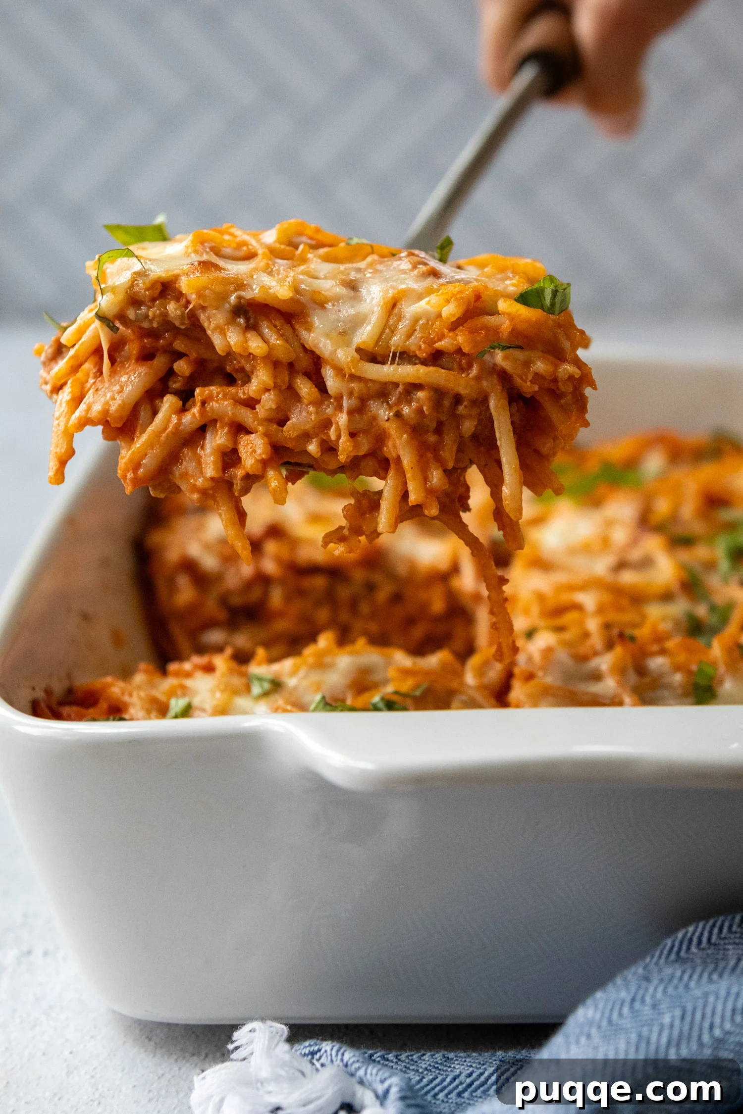 Scrumptious Gluten-Free Spaghetti Bake 2 Overhead shot of a piece casserole being lifted out of baking dish by a utensil.