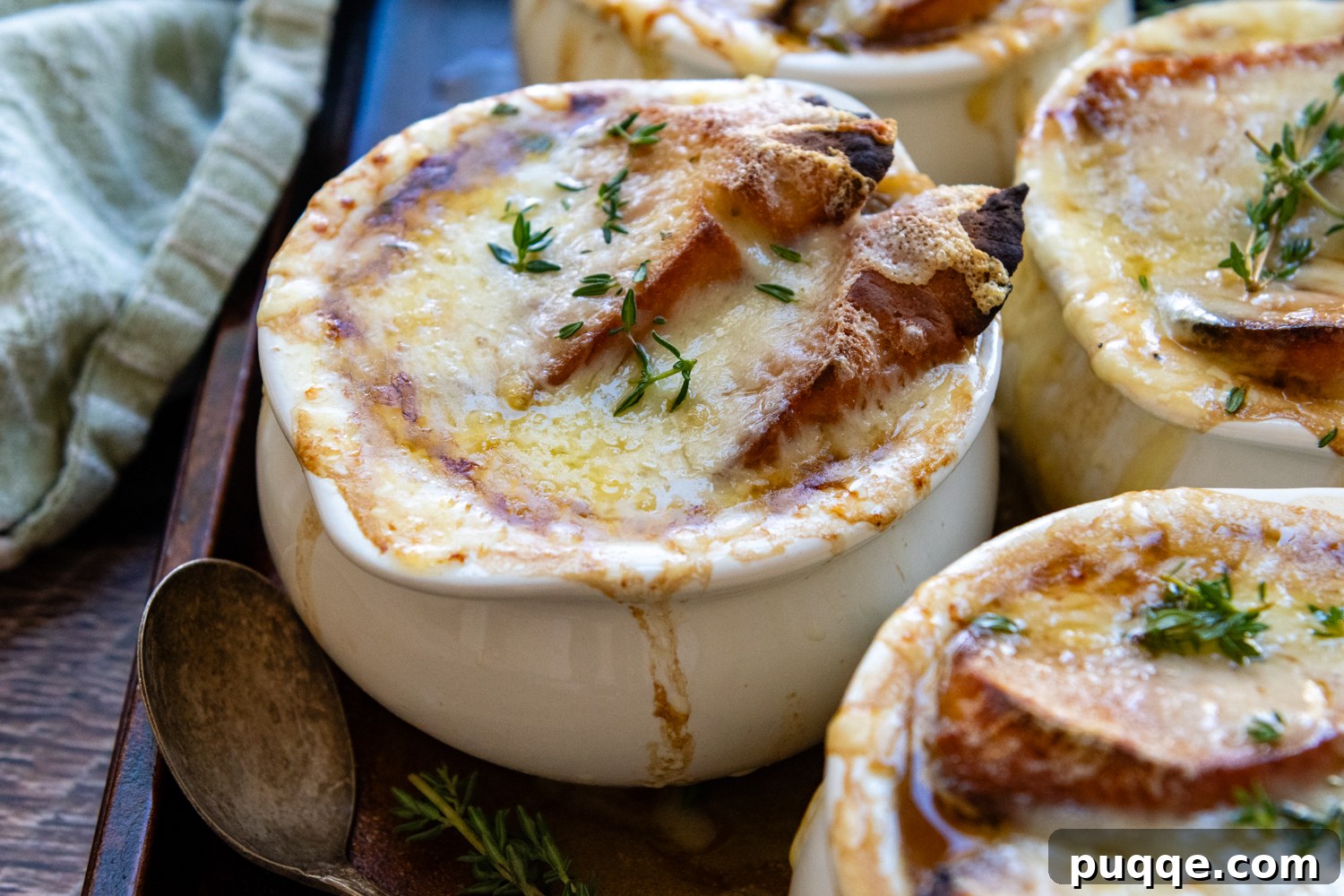 Easy Gourmet Gluten-Free French Onion Soup 12 A delicious bowl of Gluten-Free French Onion Soup, topped with a golden-brown, bubbly layer of melted Gruyere cheese and a toasted gluten-free baguette slice.
