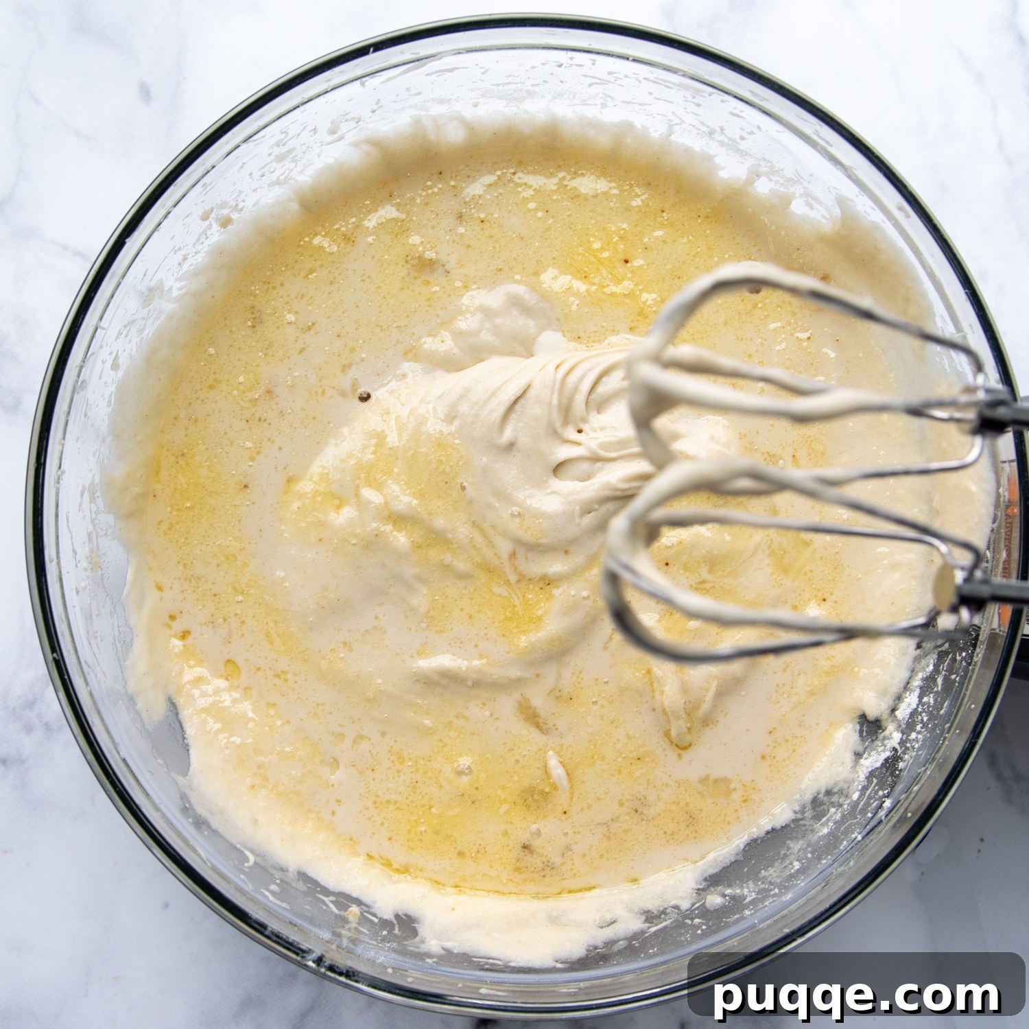 Fluffy Gluten-Free Funfetti Birthday Delight 5 Combined wet and dry ingredients in a glass bowl with electric beaters, demonstrating the unique mixing process for gluten-free cake.