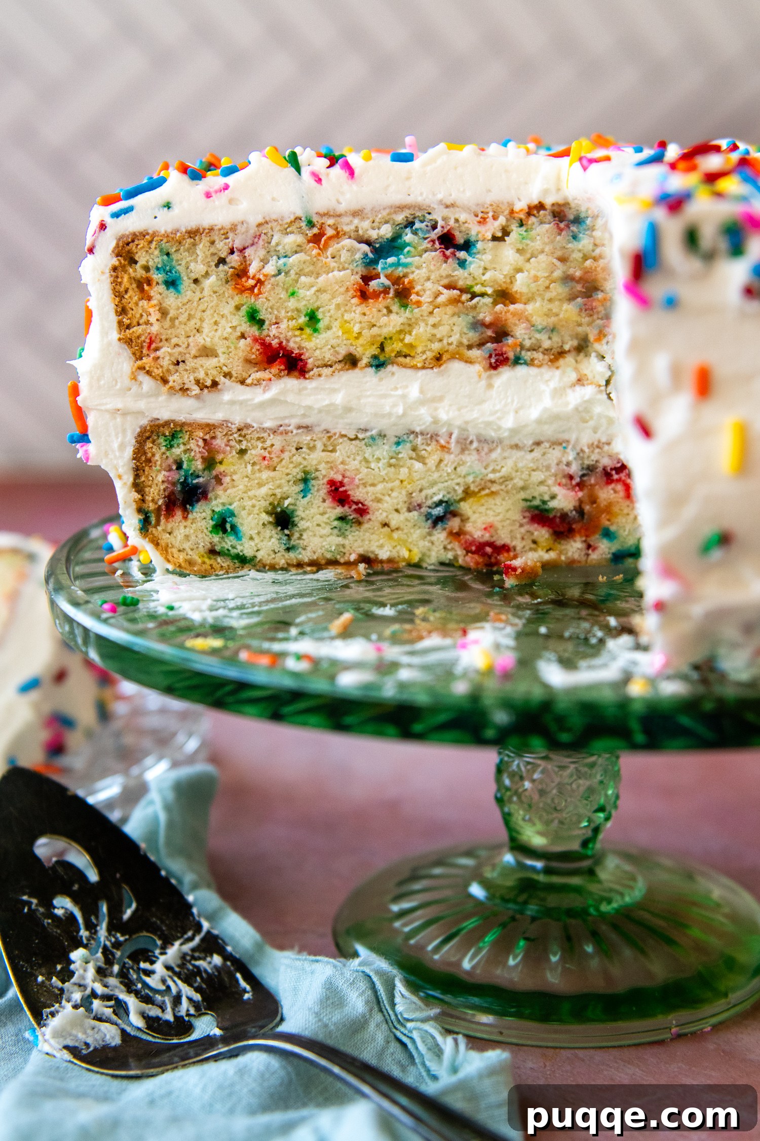 Fluffy Gluten-Free Funfetti Birthday Delight 8 A stunning two-layer gluten-free funfetti cake with a slice removed, showcasing its moist interior and vibrant sprinkles, on a glass cake stand.