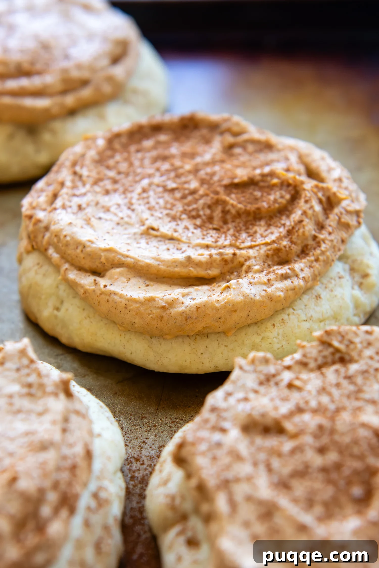 Two deliciously frosted Gluten-Free Pumpkin Cream Pie Cookies, showcasing their thick base and fluffy topping, ready to welcome fall flavors.