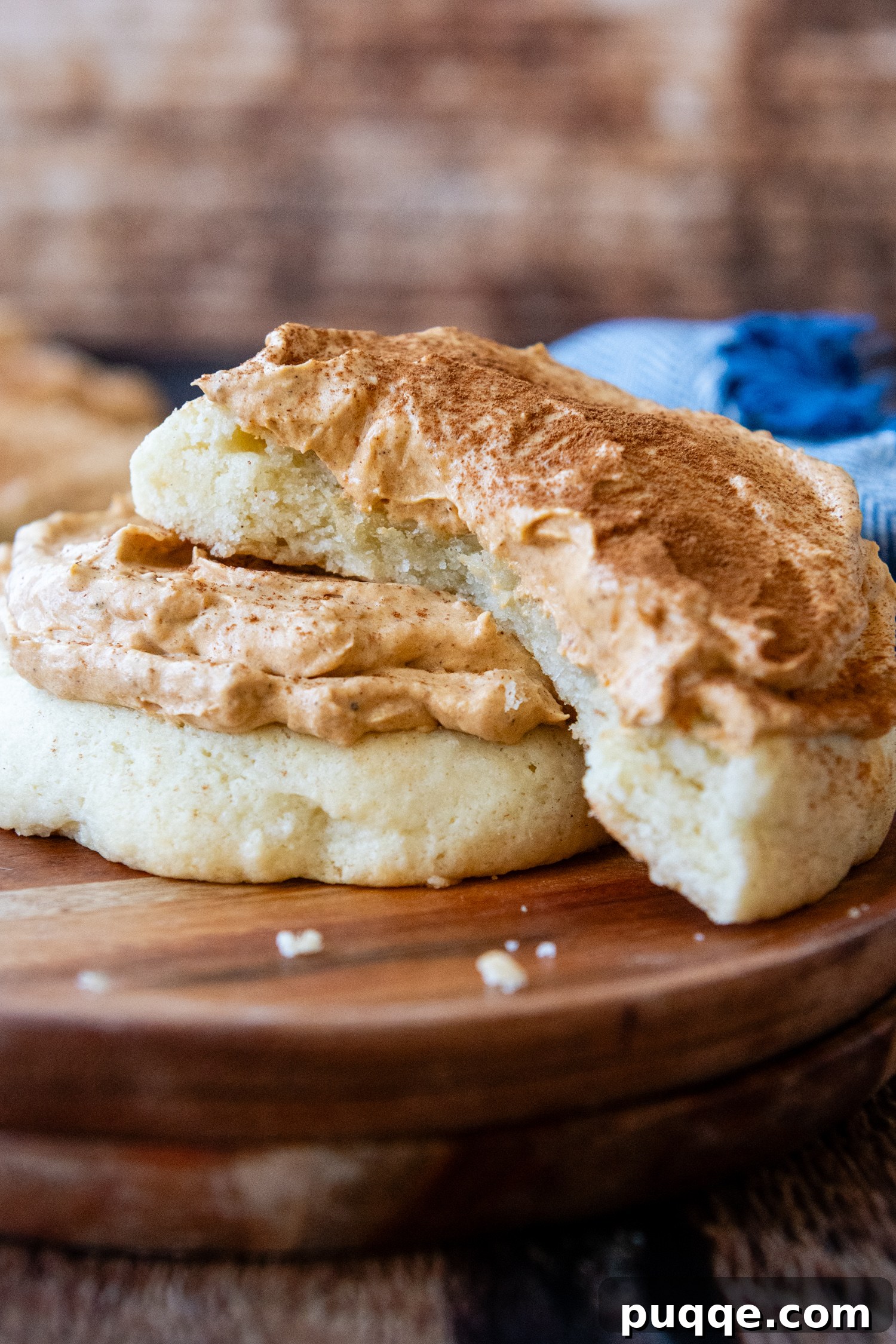 A perfectly frosted gluten-free pumpkin cream pie cookie, artfully placed to highlight its appealing texture and rich color.