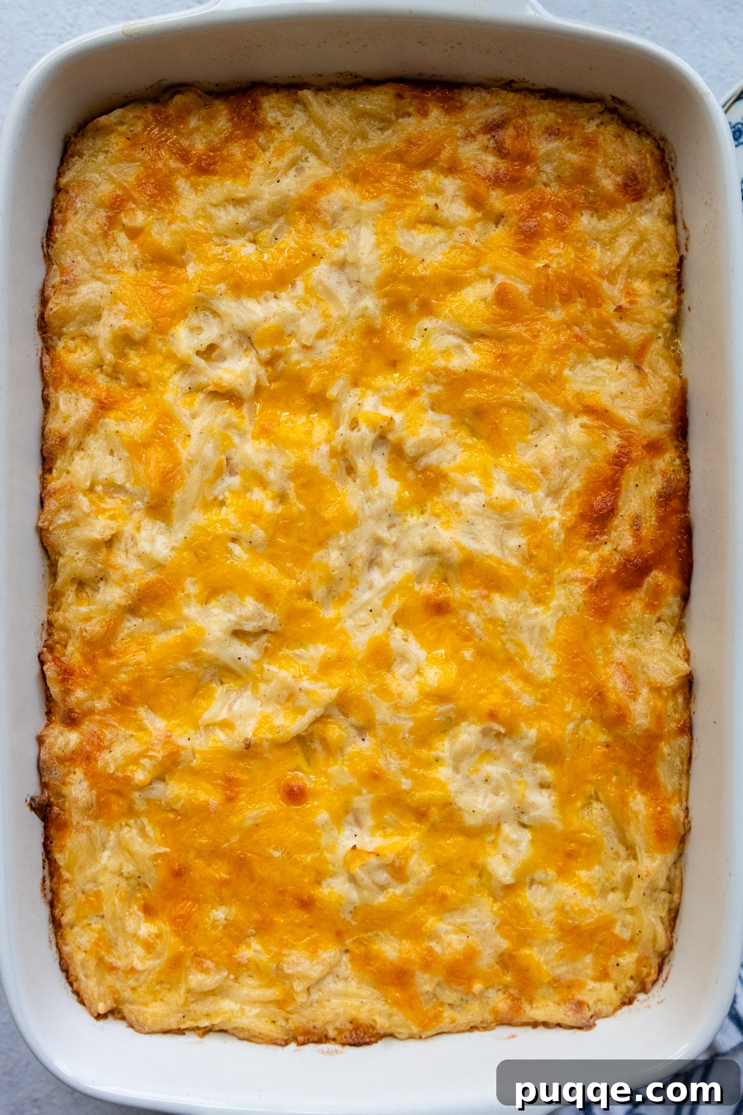 Ultimate Cheesy Gluten-Free Hash Brown Bake from Scratch 8 An inviting overhead shot of the Cheesy Gluten-Free Hash Brown Casserole in a white baking dish, showcasing its abundant, golden-brown melted cheese topping.
