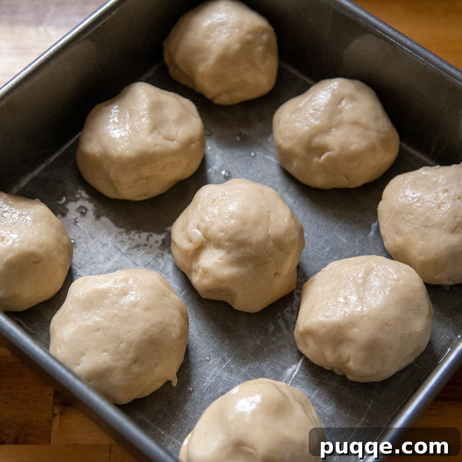 Gluten-Free Hawaiian Rolls: Squishy Soft in Just One Hour 5 Raw gluten-free Hawaiian dough balls neatly arranged in a square baking pan, ready for rising.