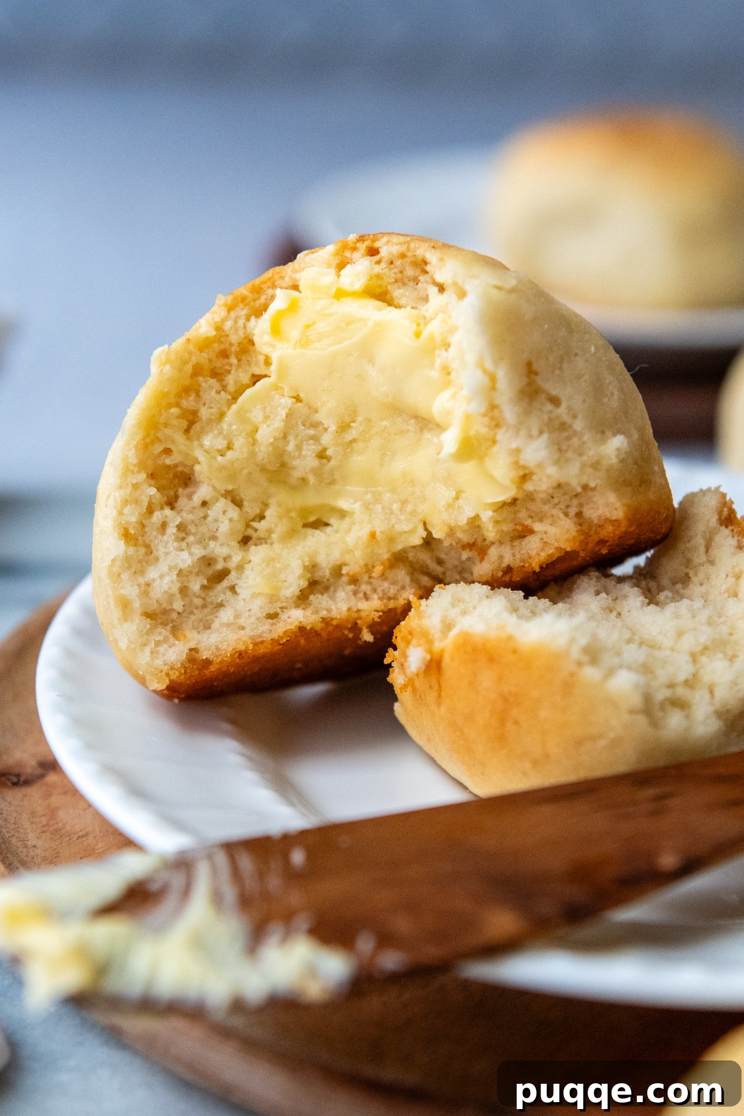 Gluten-Free Hawaiian Rolls: Squishy Soft in Just One Hour 9 A gluten-free Hawaiian roll torn open, with a generous spread of butter, highlighting its soft, airy interior.