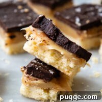 Stack of gluten free millionaire bars, showing layers of shortbread, caramel, and chocolate.