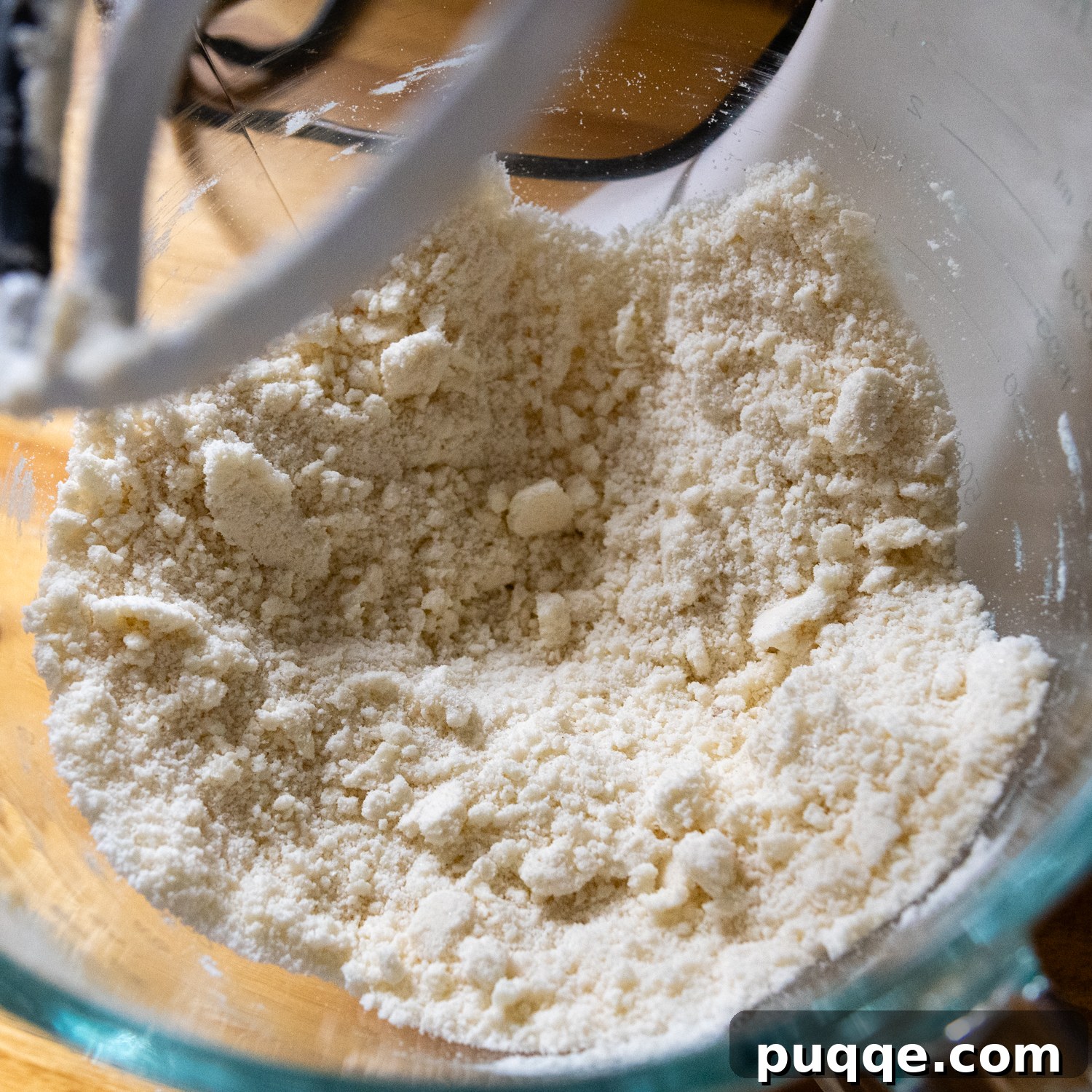 Effortless Gluten-Free Millionaire Bars 3 Dry ingredients in a mixing bowl with pieces of butter, showing a sandy texture.