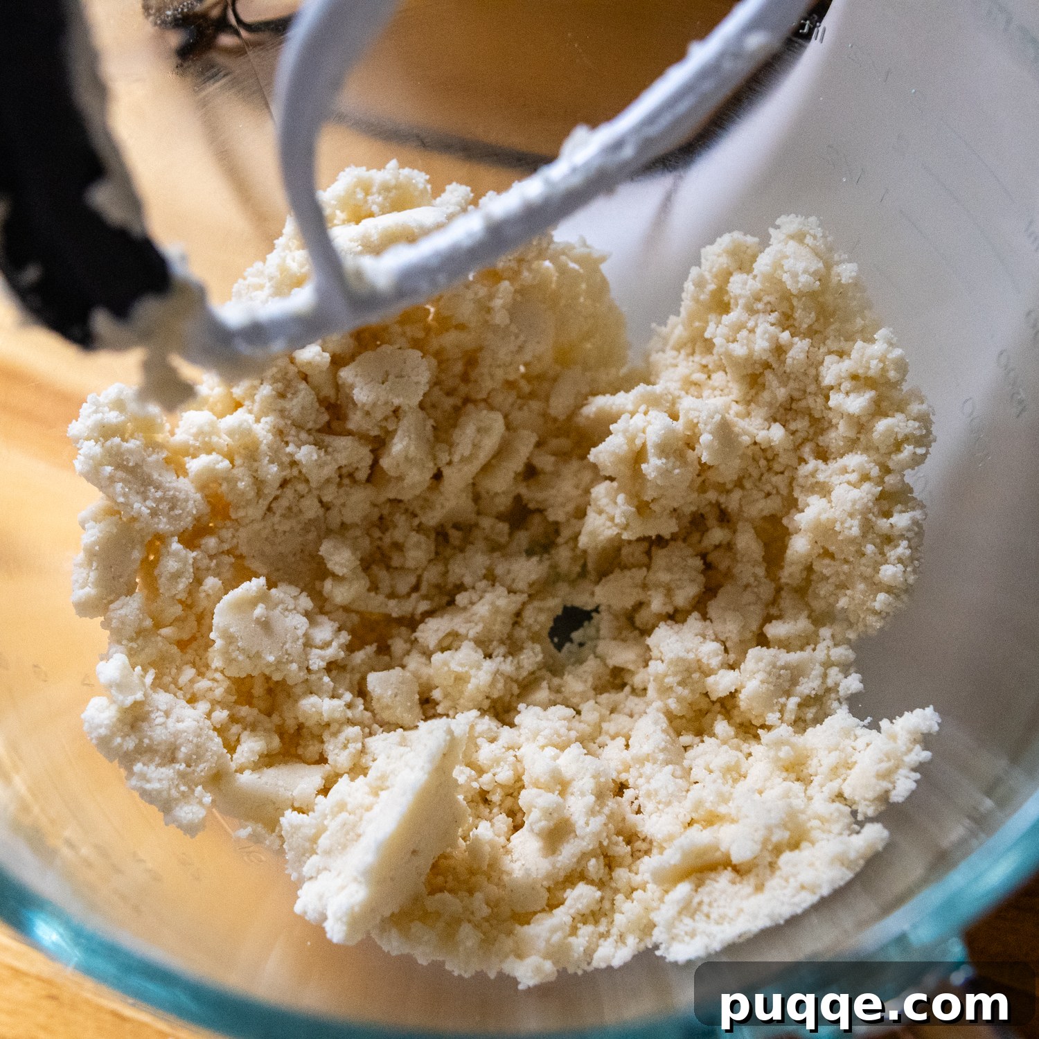 Effortless Gluten-Free Millionaire Bars 4 Ingredients in a glass mixing bowl, showing the shortbread mixture clumping together.