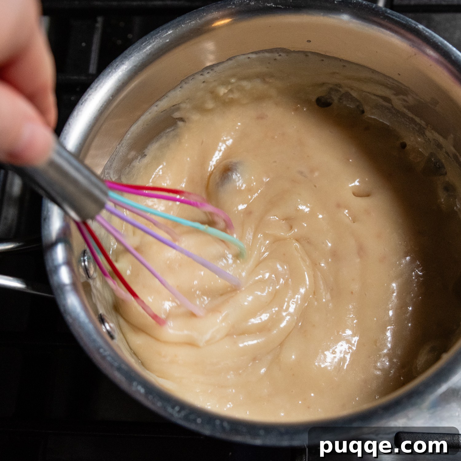 Effortless Gluten-Free Millionaire Bars 7 Caramel layer being whisked in a saucepan, showing its smooth consistency.
