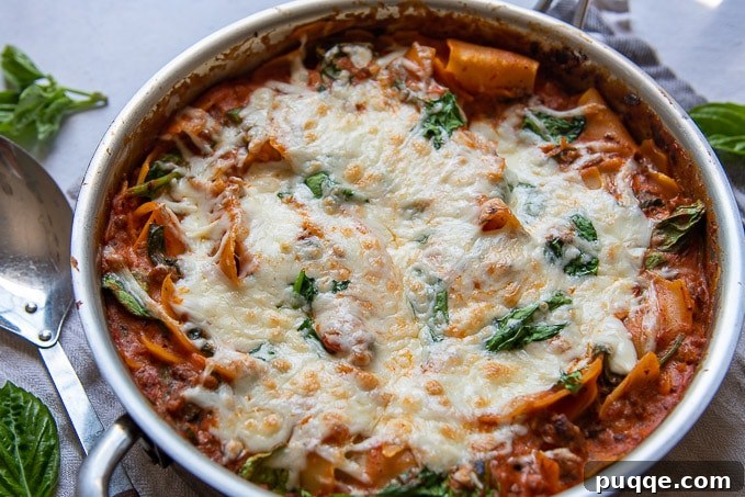 One-Pan Ricotta Spinach Lasagna 5 A vibrant landscape image of one pan lasagna, featuring melted cheese and fresh spinach on top, inviting you to dig in.