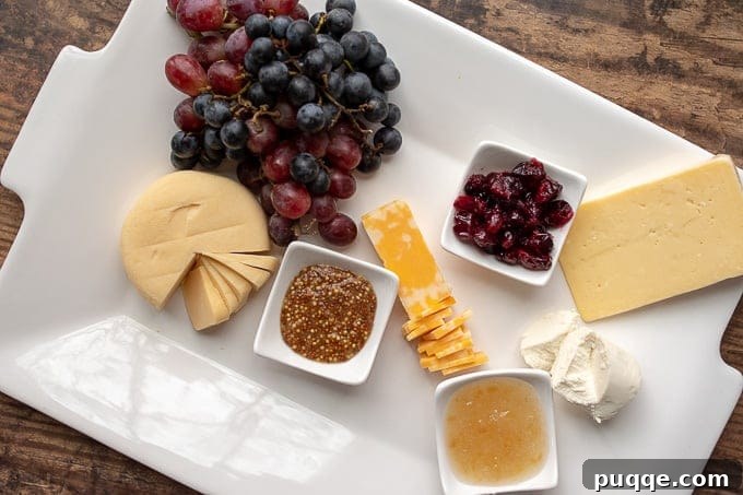Creative Charcuterie Boards 5 Second step in assembling a charcuterie board: strategically placing various cheeses and small dishes of spreads on the platter.