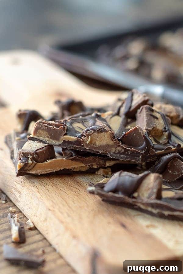 Gluten-Free 3-Ingredient Chocolate Peanut Butter Bark 3 A side-angle photo of luscious Tiger Butter candy pieces arranged on a rustic wooden cutting board.