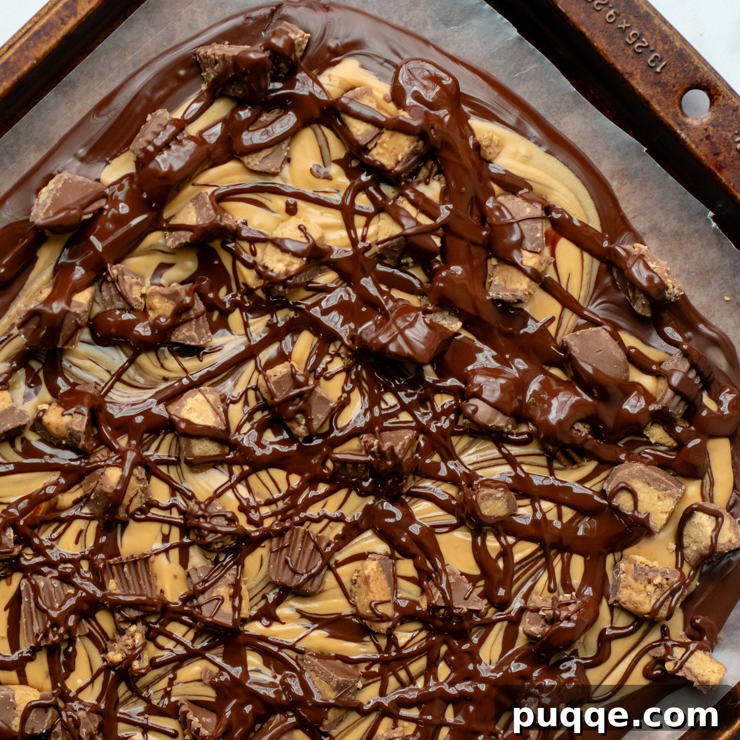 Gluten-Free 3-Ingredient Chocolate Peanut Butter Bark 7 Melted chocolate drizzled over the top of the peanut butter chocolate mixture with scattered peanut butter cups.